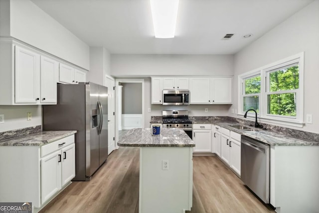 1931 Abinger Way, Lawrenceville, GA 30043 - kitchen featuring a center island, appliances with stainless steel finishes, a sink, and light stone counters