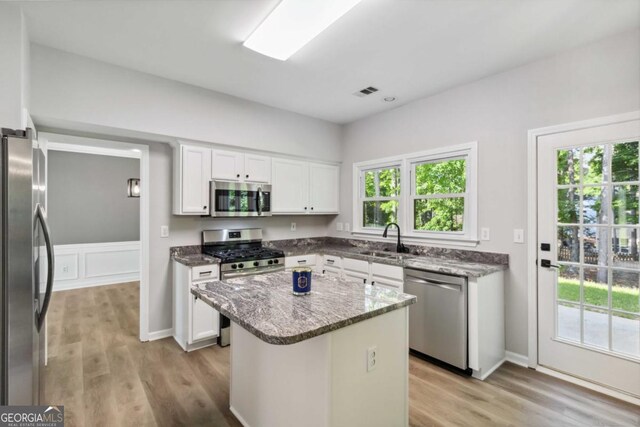1931 Abinger Way, Lawrenceville, GA 30043 - kitchen with a sink, appliances with stainless steel finishes, light wood-type flooring, and white cabinetry