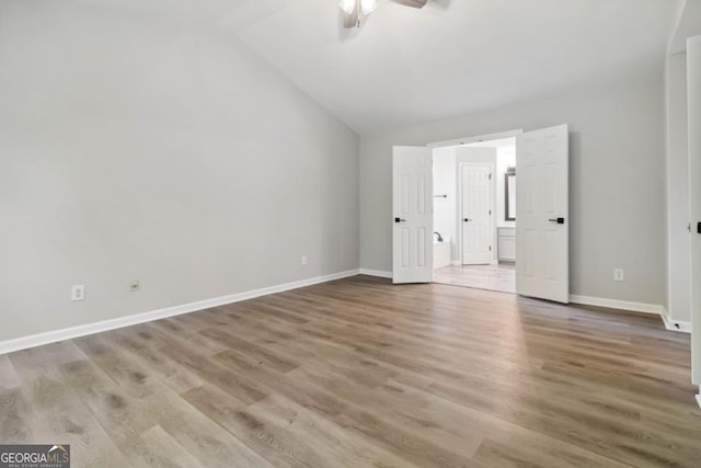 1931 Abinger Way, Lawrenceville, GA 30043 - unfurnished bedroom with vaulted ceiling, wood finished floors, a ceiling fan, and ensuite bath