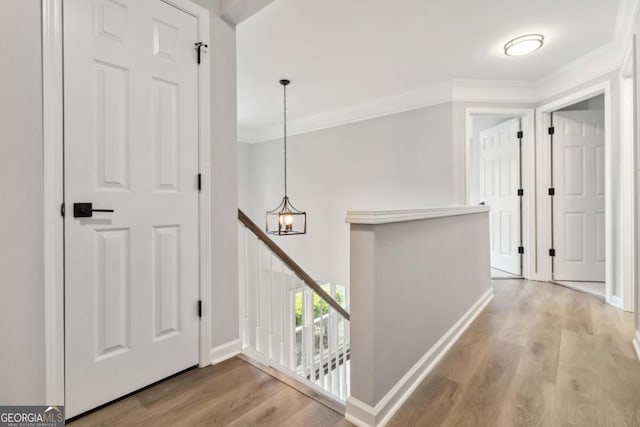 1931 Abinger Way, Lawrenceville, GA 30043 - corridor with crown molding, an inviting chandelier, wood finished floors, and an upstairs landing