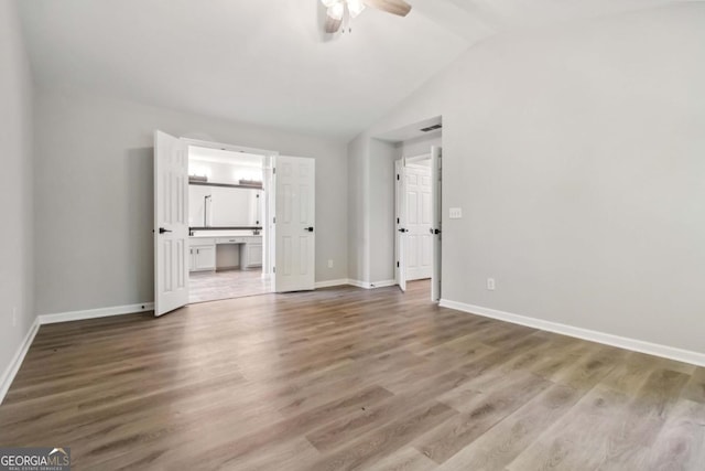 1931 Abinger Way, Lawrenceville, GA 30043 - unfurnished living room with vaulted ceiling, baseboards, a ceiling fan, and wood finished floors