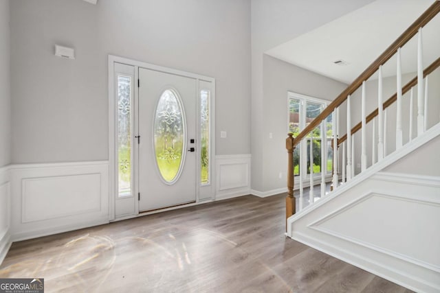 1931 Abinger Way, Lawrenceville, GA 30043 - foyer entrance with wood finished floors, stairs, a decorative wall, and wainscoting