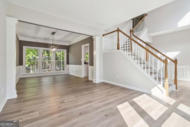 1931 Abinger Way, Lawrenceville, GA 30043 - unfurnished living room featuring wood finished floors, a decorative wall, stairway, and a wainscoted wall