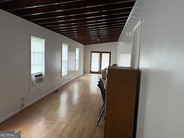 interior space featuring baseboards, cooling unit, and light wood finished floors