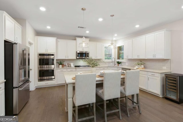 kitchen featuring beverage cooler, light countertops, white cabinetry, a sink, and stainless steel appliances