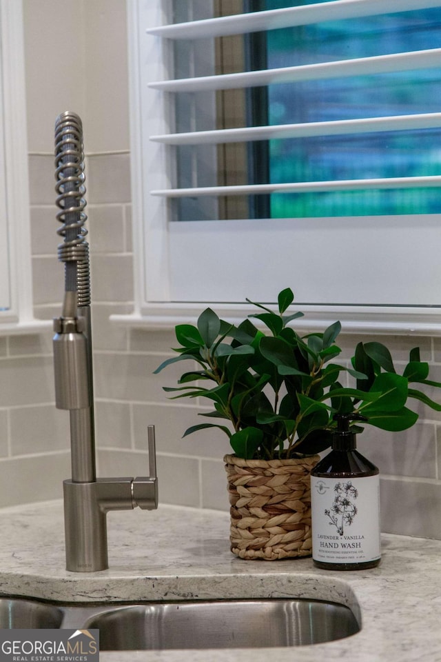 interior details featuring light stone countertops and decorative backsplash