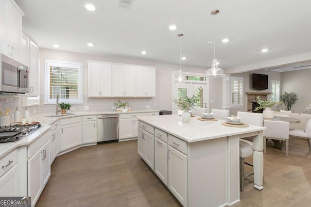 kitchen featuring backsplash, stainless steel appliances, a breakfast bar, and a sink