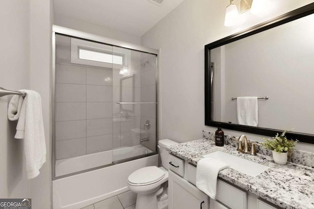 bathroom with vanity, enclosed tub / shower combo, tile patterned flooring, and toilet