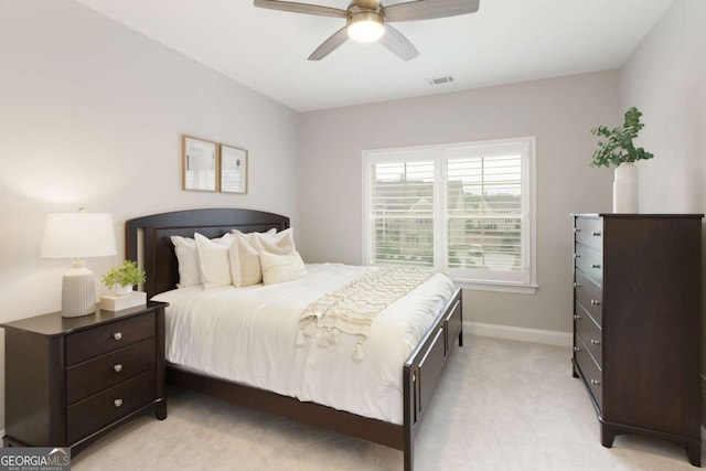 bedroom with baseboards, ceiling fan, light carpet, and visible vents