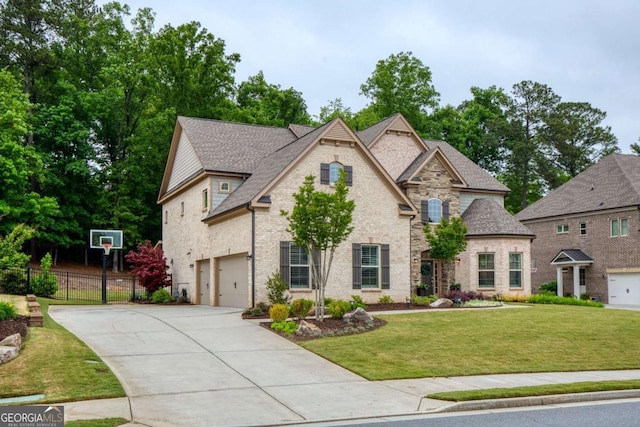 view of front of property featuring a front lawn, fence, brick siding, a shingled roof, and concrete driveway