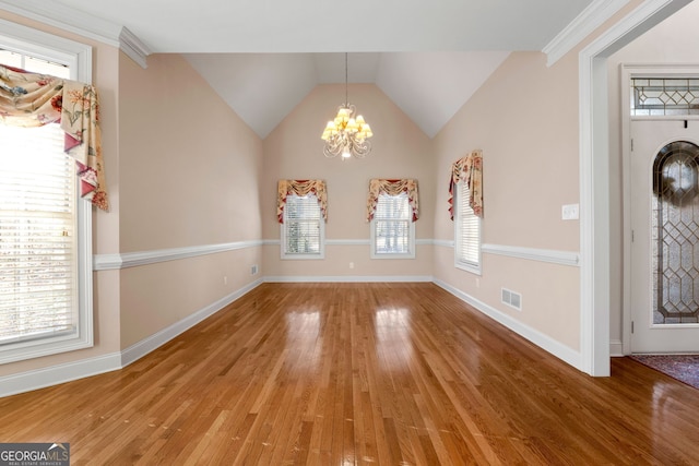 unfurnished dining area featuring an inviting chandelier, baseboards, wood finished floors, and visible vents