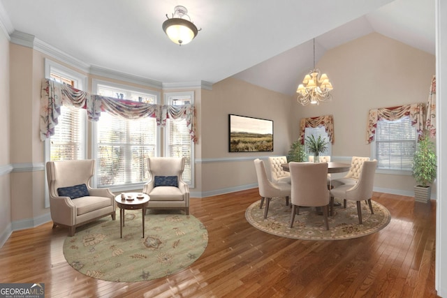 dining space with crown molding, baseboards, an inviting chandelier, and wood finished floors