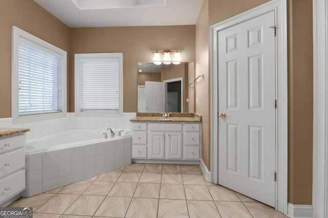 bathroom featuring tile patterned flooring, a garden tub, and vanity