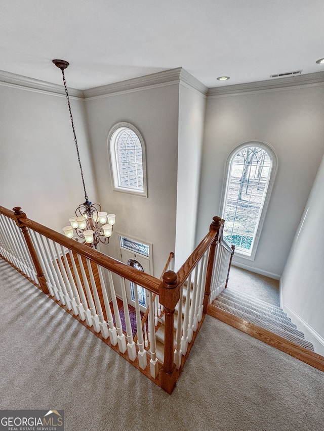 stairs featuring carpet floors, ornamental molding, baseboards, and visible vents