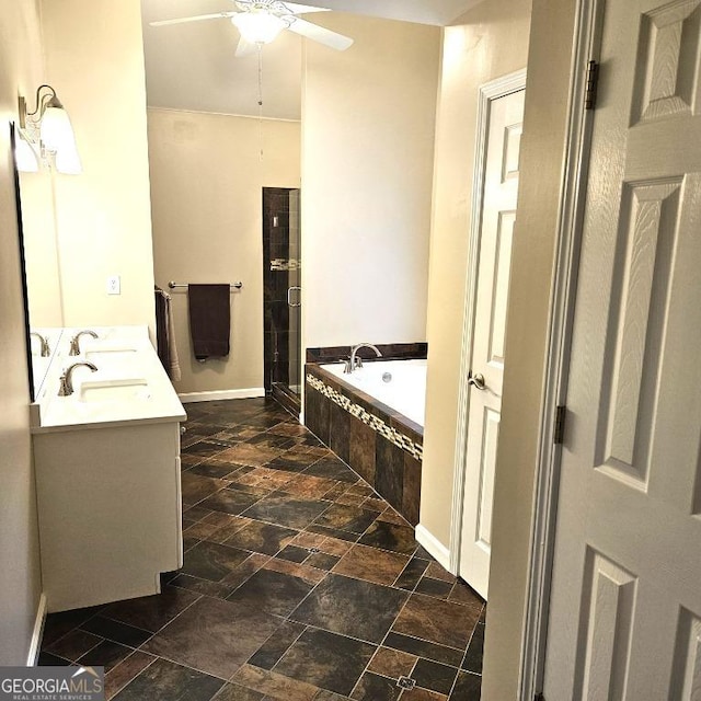 full bath with double vanity, a ceiling fan, a shower stall, a bath, and stone tile flooring