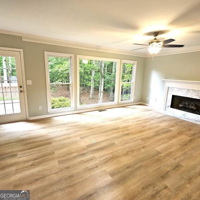 unfurnished living room featuring a healthy amount of sunlight, baseboards, and wood finished floors