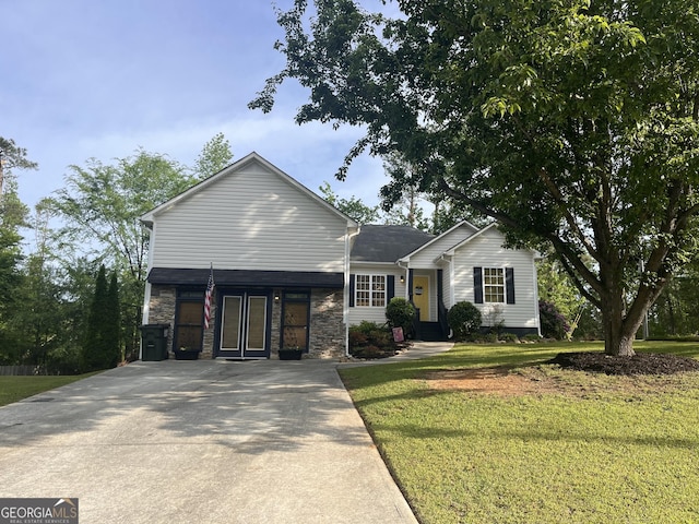 view of front of property with a front yard, driveway, and stone siding