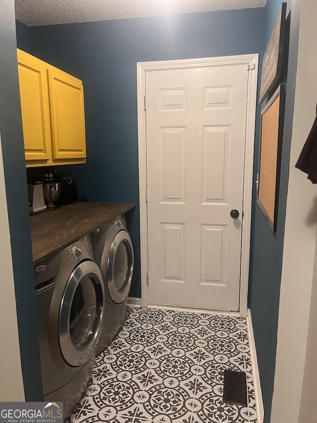 laundry room featuring visible vents, baseboards, a textured ceiling, cabinet space, and independent washer and dryer