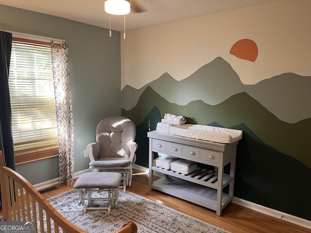 bedroom featuring baseboards, visible vents, and wood finished floors
