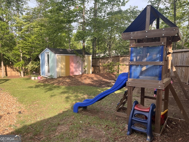 view of jungle gym with a fenced backyard, a storage unit, and a yard