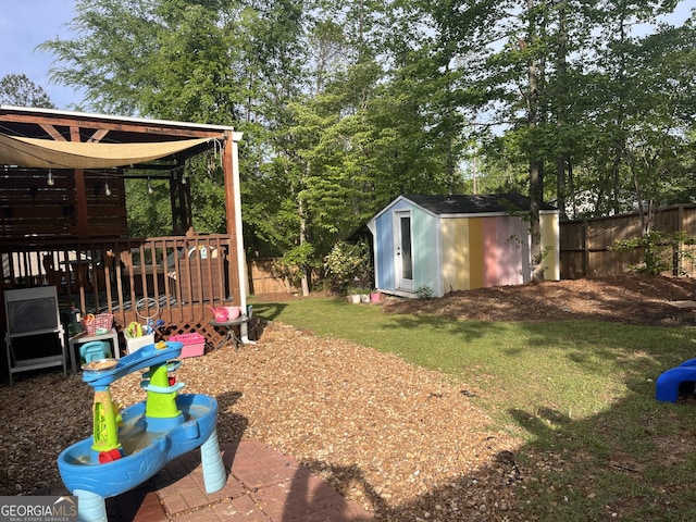 view of yard with an outdoor structure, a fenced backyard, and a shed