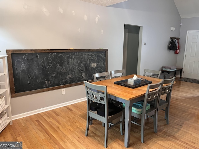 dining room with light wood-style flooring and lofted ceiling
