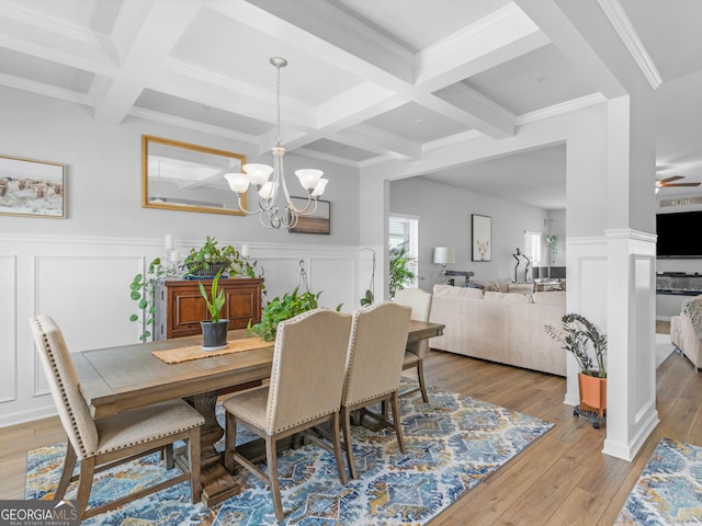 dining room featuring light wood-type flooring, coffered ceiling, and beamed ceiling