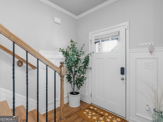 entryway featuring stairway, crown molding, and wood finished floors
