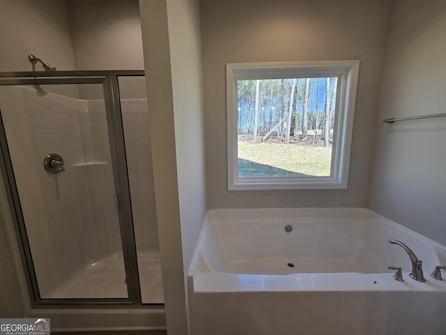 bathroom featuring a stall shower and a garden tub