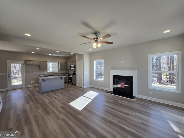 unfurnished living room featuring baseboards, a ceiling fan, recessed lighting, and dark wood-type flooring