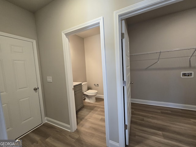 bathroom with vanity, baseboards, toilet, and wood finished floors