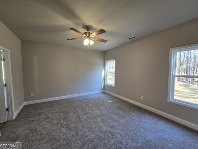 unfurnished room with visible vents, a ceiling fan, baseboards, and carpet