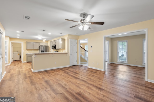 6939 Waters Edge Dr, Stone Mountain, GA 30087 - kitchen featuring visible vents, a peninsula, light wood-style flooring, and appliances with stainless steel finishes