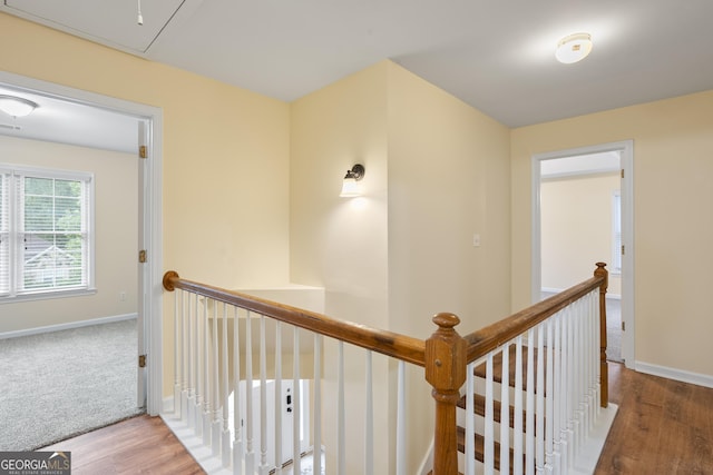 6939 Waters Edge Dr, Stone Mountain, GA 30087 - hallway featuring baseboards, attic access, wood finished floors, and an upstairs landing
