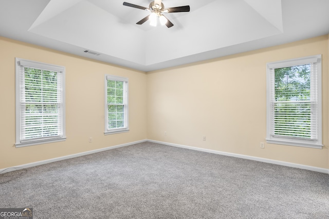 6939 Waters Edge Dr, Stone Mountain, GA 30087 - carpeted empty room with a tray ceiling, visible vents, a healthy amount of sunlight, and ceiling fan