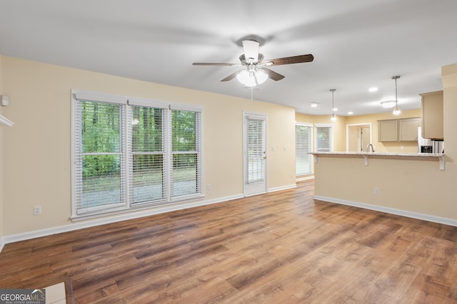 6939 Waters Edge Dr, Stone Mountain, GA 30087 - unfurnished living room featuring baseboards, ceiling fan, and a healthy amount of sunlight