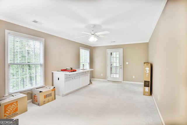 interior space featuring baseboards, visible vents, ornamental molding, and multiple windows