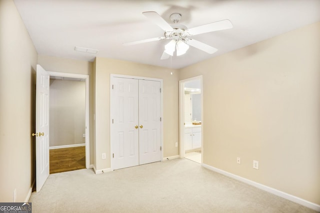 unfurnished bedroom with carpet floors, a closet, baseboards, ensuite bathroom, and ceiling fan
