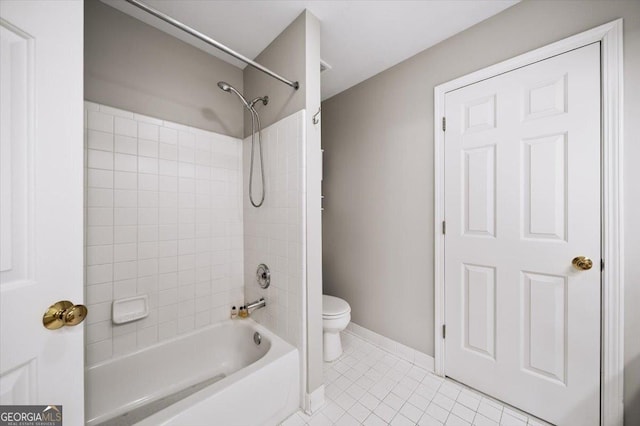 bathroom featuring tile patterned floors, baseboards, toilet, and  shower combination