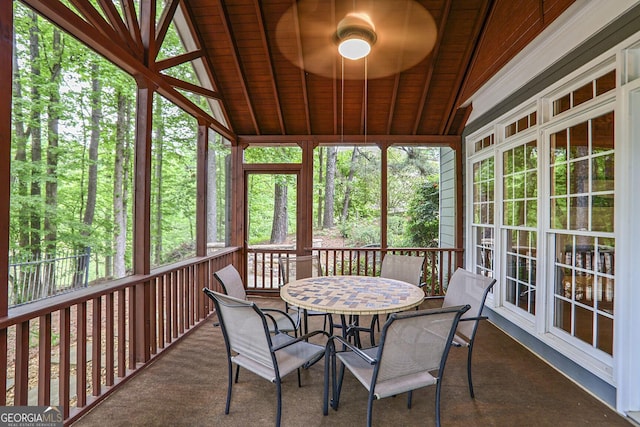 sunroom with beamed ceiling, outdoor dining area, and ceiling fan