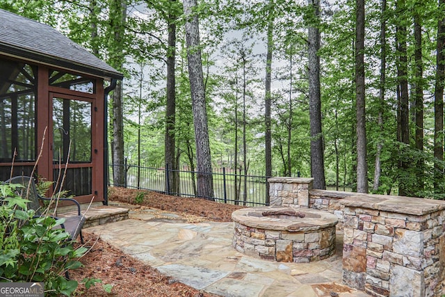 view of patio featuring fence and a fire pit
