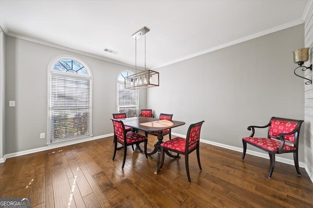 dining room with visible vents, crown molding, baseboards, dark wood-type flooring, and a chandelier