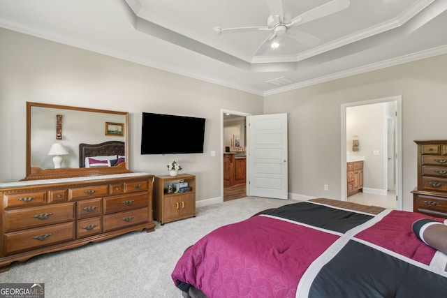 bedroom featuring ornamental molding, baseboards, ensuite bathroom, light colored carpet, and a tray ceiling