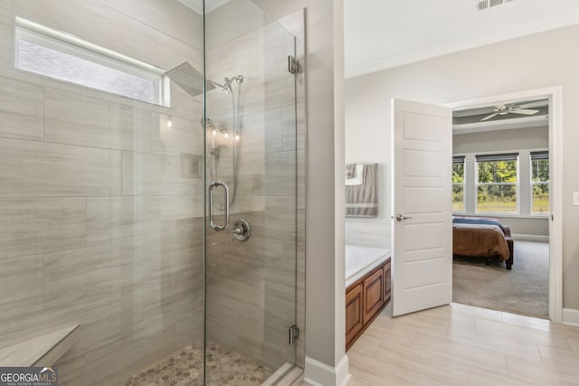 ensuite bathroom with a stall shower, ceiling fan, baseboards, and ensuite bath