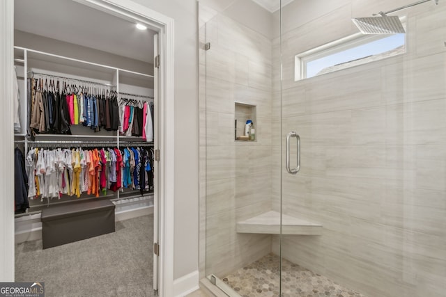 bathroom with a shower stall and a spacious closet
