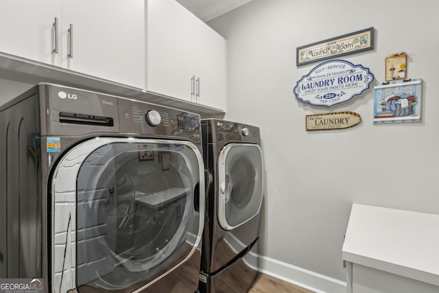 clothes washing area with baseboards, cabinet space, independent washer and dryer, and wood finished floors