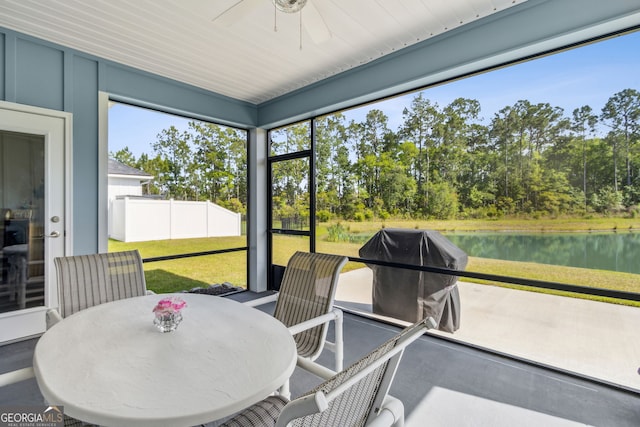 sunroom / solarium with a ceiling fan, a healthy amount of sunlight, and a water view