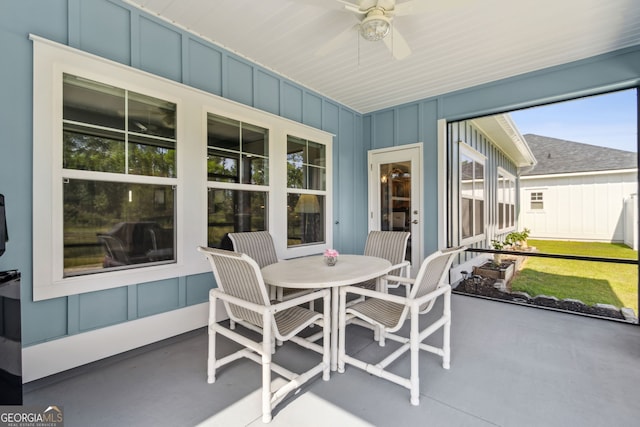 sunroom / solarium with outdoor dining area and a ceiling fan