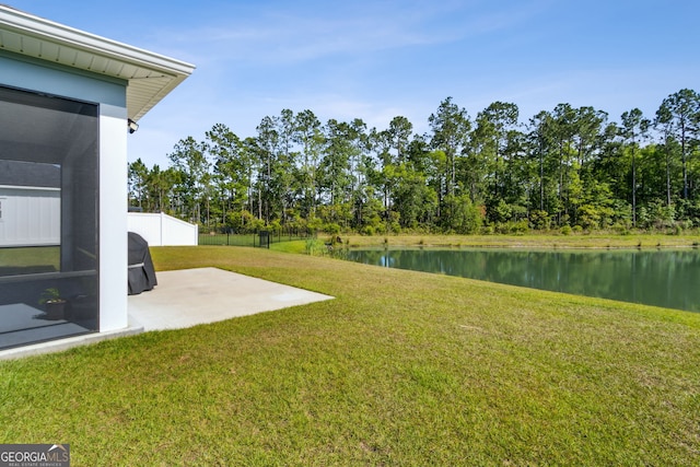 view of yard with fence, a water view, and a patio area