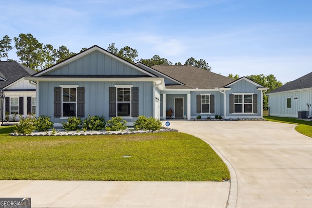 view of front facade with board and batten siding, cooling unit, driveway, and a front yard